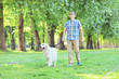 Young man walking his dog in a park