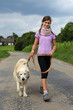 Mädchen geht draußen mit Hund spazieren